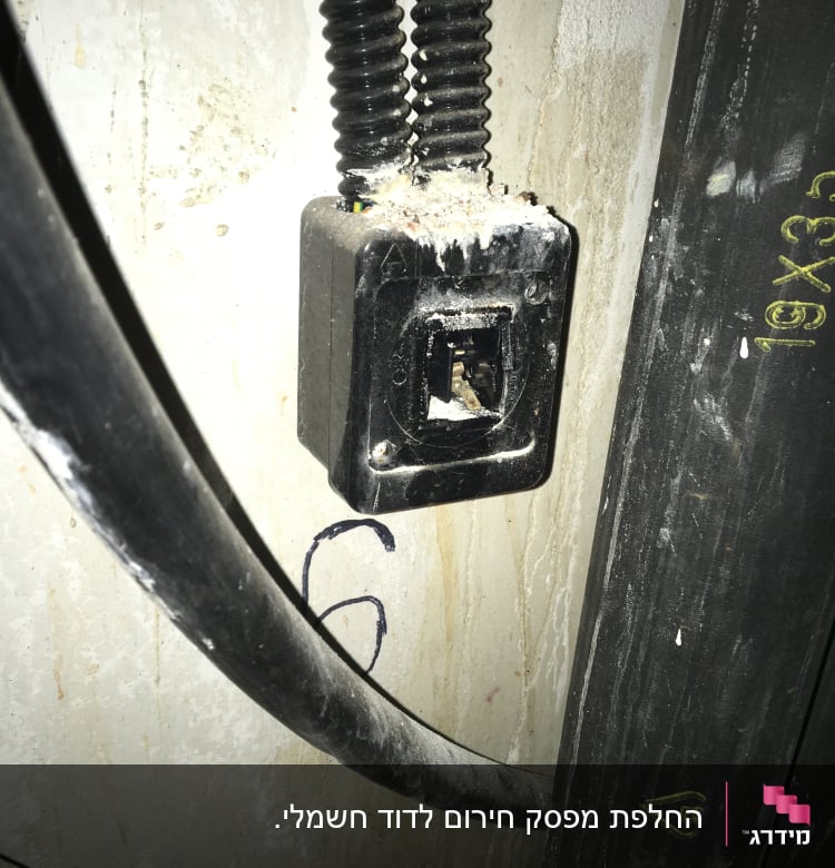 שקע חשמלי עם חוטים חשופים על קיר